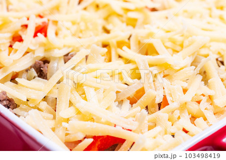 Raw casserole with potatoes, sausage and colorful bell pepper, closeup in baking dish, horizontal Raw casserole with potatoes, sausage and colorful bell pepper, closeup in baking dish, horizontal 103498419