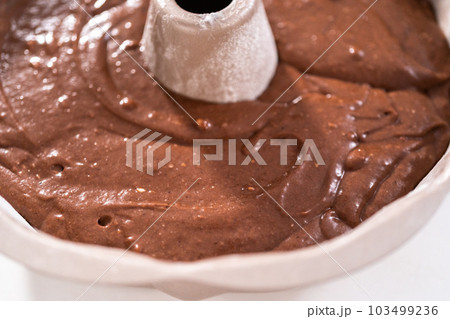 Chocolate cake batter in a metal bundt cake pan ready for baking. Chocolate cake batter in a metal bundt cake pan ready for baking. 103499236