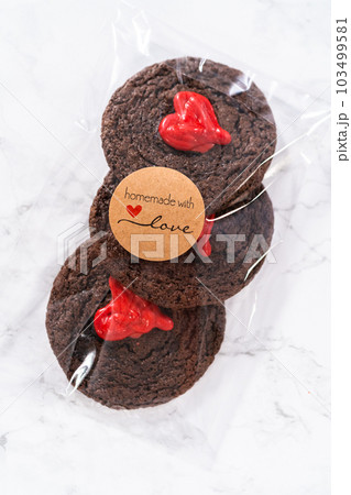 Chocolate cookies with chocolate hearts for Valentine's Day packaged in plastic gift bags. 103499581