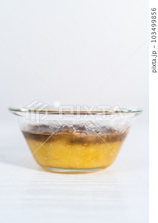 Mashed overripe banana in a glass mixing bowl. 103499856