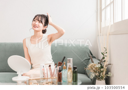 部屋で頭皮ブラッシング・ シャンプーブラシ・ヘッドブラシでヘッドマッサージ・スカルプケアをする女性 103500554