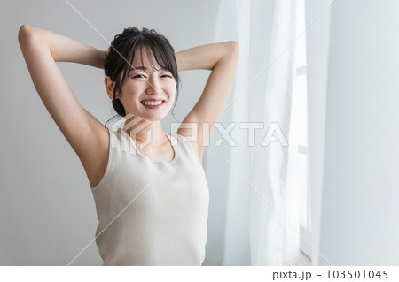 寝起き・起床時にカーテンの前でストレッチをする女性（セロトニン・リフレッシュ・柔軟体操） 103501045