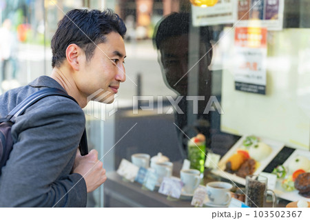 飲食店のショーウィンドウを見る男性 飲食店のショーウィンドウを見る男性 103502367
