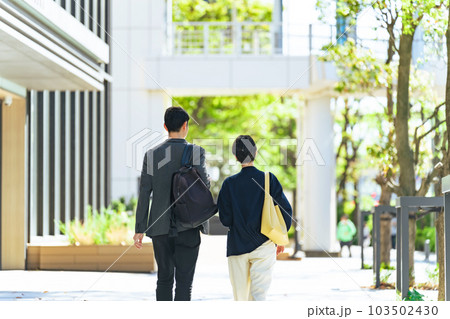 おしゃれな街を歩くカップルの後ろ姿 103502430