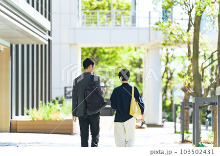 おしゃれな街を歩くカップルの後ろ姿 103502431