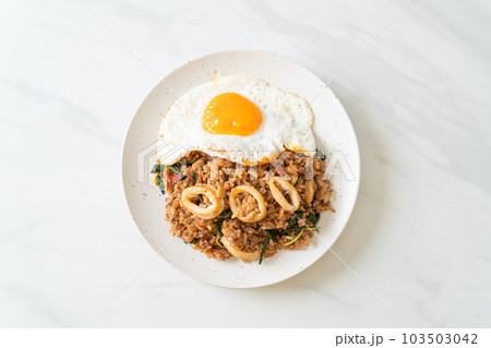 fried rice with squid and basil topped fried egg in Thai style fried rice with squid and basil topped fried egg in Thai style 103503042