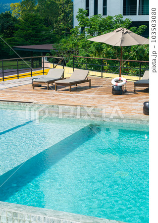 bed pool with umbrella around swimming pool 103503080