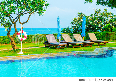 chair pool  or bed pool and umbrella around swimming pool with sea background 103503094