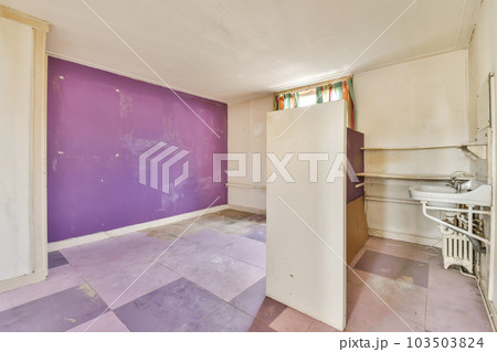 an empty room with purple paint on the walls and white trim around the door to the left is a sink 103503824