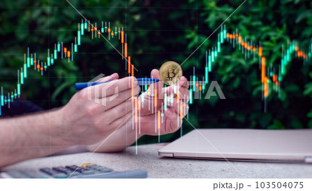 Laptop with chart and bitcoin in hands. Cryptocurrency gold coin, stock exchange graph background. 103504075