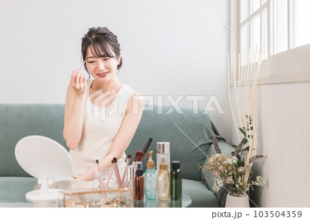 家でメイク中にアイシャドウを塗る女性 家でメイク中にアイシャドウを塗る女性 103504359