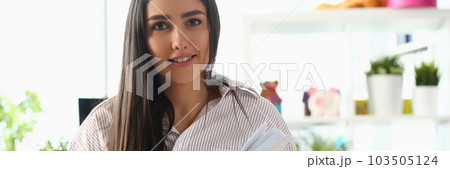 Beautiful woman is sitting on bed and holding diary Beautiful woman is sitting on bed and holding diary 103505124