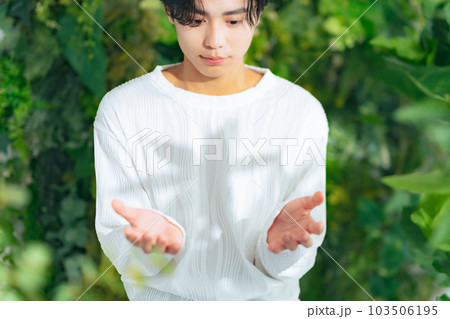 緑の前で手のひらをかざす男性 緑の前で手のひらをかざす男性 103506195