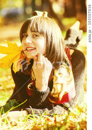 portrait of a happy girl without makeup lying on the ground in an autumn park portrait of a happy girl without makeup lying on the ground in an autumn park 103507816