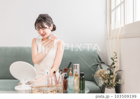 家で首にマッサージローラーを使う若いアジア人女性 家で首にマッサージローラーを使う若いアジア人女性 103509199