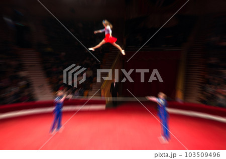 Abstract blurred image of tour of circus. Acrobats on poles on arena in defocus 103509496