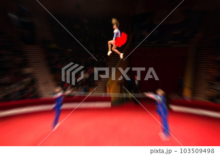 Abstract blurred image of tour of circus. Performance of acrobats on poles on arena in defocus Abstract blurred image of tour of circus. Performance of acrobats on poles on arena in defocus 103509498