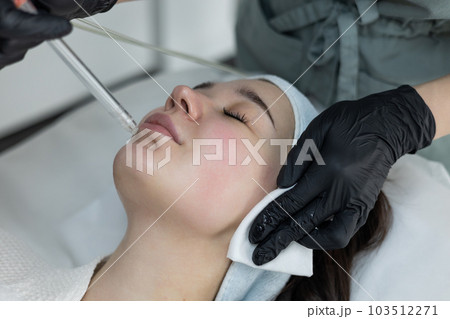 Girl getting oxygen face therapy in a beauty salon. Oxygen mesotherapy. 103512271