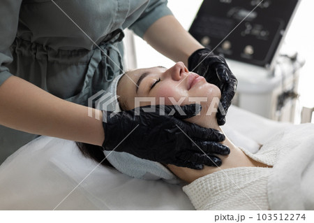 Woman is treated to a professional gel peeling mask at the clinic, skin care. 103512274