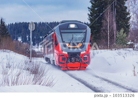 Passenger train moves fast at winter day. Passenger train moves fast at winter day. 103513326