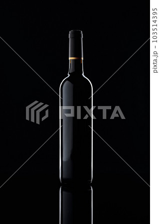 Bottle and glass of red wine on a black background. Bottle and glass of red wine on a black background. 103514395