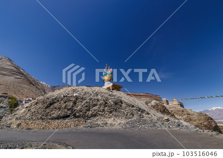 Big Sitting Buddha Statue at Diskit Monastery with Himalaya Range in the back - Nubra Valley, Ladakh, India. 103516046