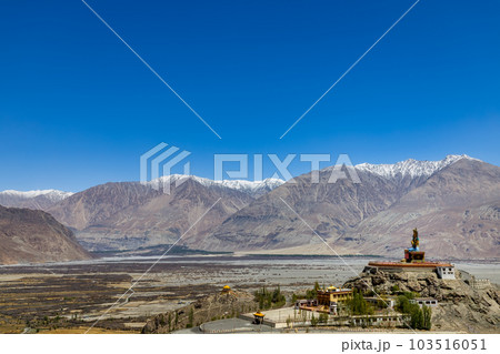 Big Sitting Buddha Statue at Diskit Monastery with Himalaya Range in the back - Nubra Valley, Ladakh, India. Big Sitting Buddha Statue at Diskit Monastery with Himalaya Range in the back - Nubra Valley, Ladakh, India. 103516051