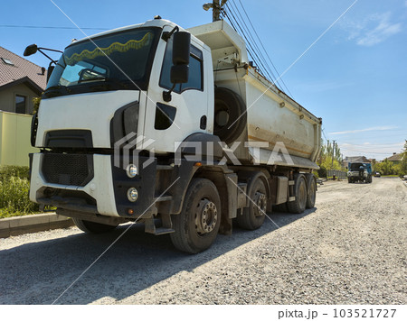 Still life with a truck carrying construction sand or concrete. The concept of reloading on the roads and renting a dump truck for work, road repair. Copy advertising space. 103521727