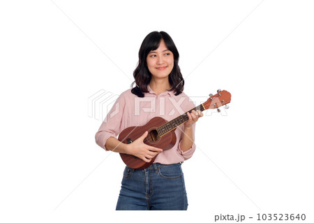 Happy young asian woman with casual clothing playing ukulele isolated on white background Happy young asian woman with casual clothing playing ukulele isolated on white background 103523640