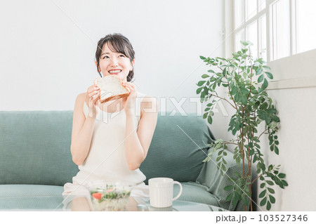 朝食に食パンとサラダを食べる笑顔のアジア人女性 朝食に食パンとサラダを食べる笑顔のアジア人女性 103527346