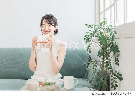 朝食に食パンとサラダを食べる笑顔のアジア人女性 朝食に食パンとサラダを食べる笑顔のアジア人女性 103527347