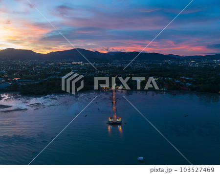 aerial photography cloud above Palai pier at beautiful sunset..Palai pier is next to Chalong pier..fishing boats parking on the beach..colorful cloud above the mountain range background.. aerial photography cloud above Palai pier at beautiful sunset..Palai pier is next to Chalong pier..fishing boats parking on the beach..colorful cloud above the mountain range background.. 103527469