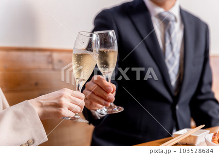 シャンパンで乾杯をする居酒屋デートするカップル 103528684