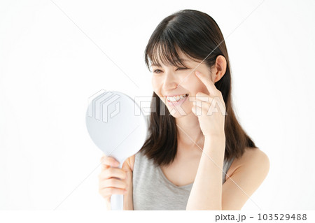 笑顔で鏡を見る女性　ビューティー 103529488