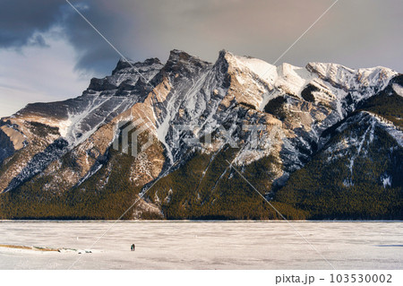 Beautiful frozen Lake Minnewanka with rocky mountains in winter on the evening at Banff national park 103530002