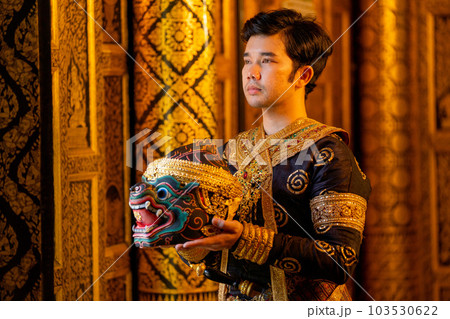 Asian man with traditional cloths relate to Khon or Thai classic masked stand with holding mask 103530622