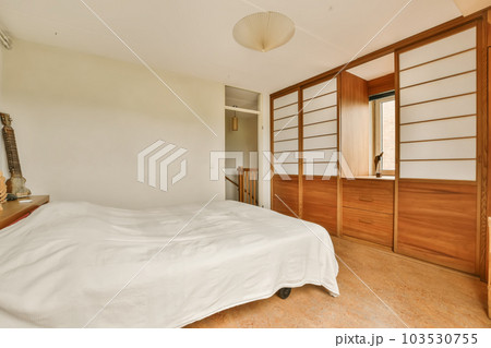 a bedroom with white sheets on the bed and wooden cabinets in the room is very clean, ready for guests to use 103530755