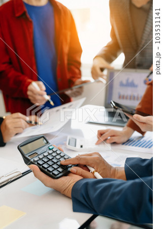 Businessman and team analyzing financial statement Finance task. with smart phone and laptop and  tablet. Wealth management concept. 103531141
