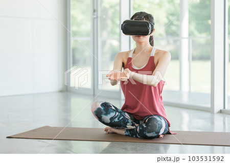 VRゴーグルをつけてヨガをする女性 VRゴーグルをつけてヨガをする女性 103531592