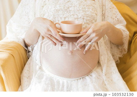 出産間近のお腹の上にティーカップを置きながらお茶をする妊婦さん マタママ プレママ 出産間近のお腹の上にティーカップを置きながらお茶をする妊婦さん マタママ プレママ 103532130