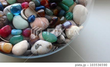 Round glass sphere with colored glass stones on a sea rocks inside Round glass sphere with colored glass stones on a sea rocks inside 103536590