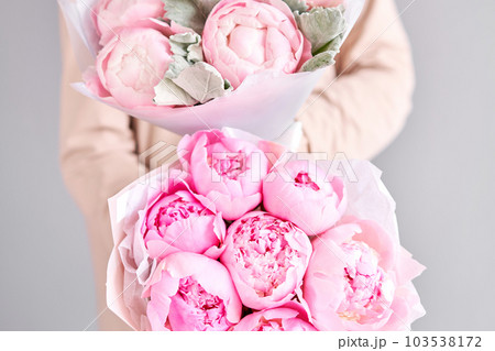 A bouquet of pink peonies in women's hands. Flower delivery. A beautiful bouquet of flowers as a gift for a holiday. A bouquet of pink peonies in women's hands. Flower delivery. A beautiful bouquet of flowers as a gift for a holiday. 103538172