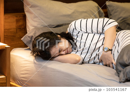 Middle aged woman touching right lower abdomen,acute abdominal pain with appendicitis,painful and inflammation of appendix,sick female patient with Ruptured Appendicitis,health care,medical concept 103541167