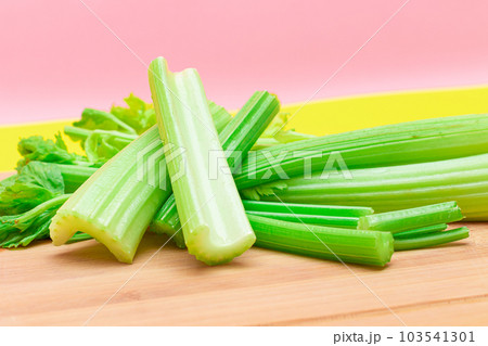 Fresh Celery Stem and Chopped Celery Sticks on Wooden Cutting Board Fresh Celery Stem and Chopped Celery Sticks on Wooden Cutting Board 103541301