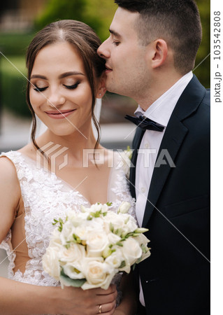 Close-up portrait of beautiful wedding couple walking outdoors. Groom and bride in the park 103542808
