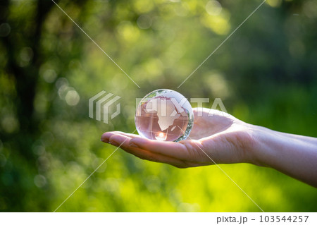Woman holds a model of planet Earth from glass. Woman holds a model of planet Earth from glass. 103544257