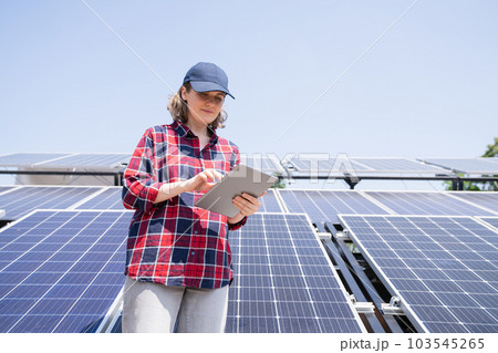Woman with tablet on a background of mobile solar power station. 103545265