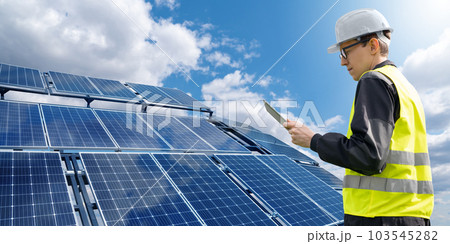Engineer with tablet computer on a background of mobile solar power station 103545282
