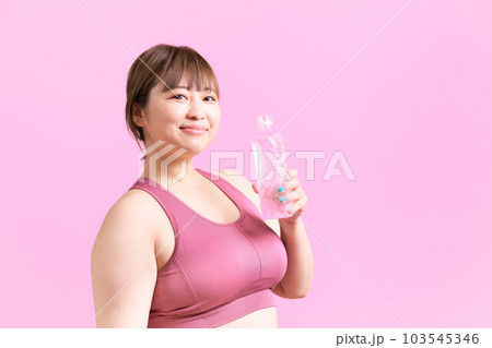 ペットボトルの水を手に持つ豊満な若い女性　プラスサイズモデル　イメージ 103545346