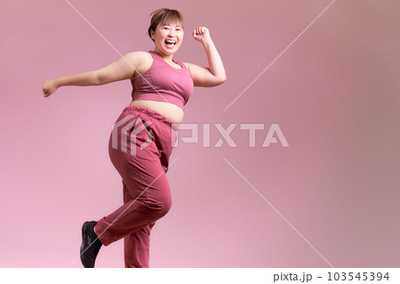 笑顔でジャンプする豊満な若い女性　プラスサイズモデル　イメージ 103545394